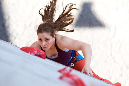 Female athlete makes hard move on climbing wallのeditorial素材