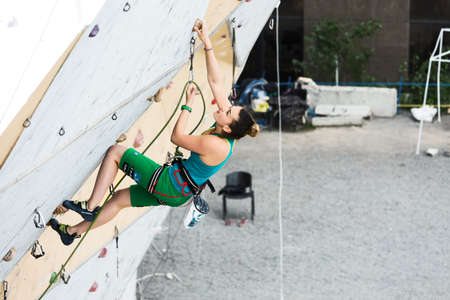 Cute female Athlete hanging on climbing Wallのeditorial素材