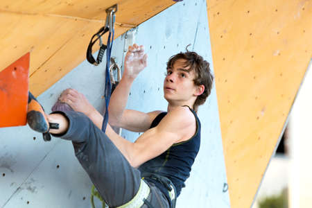 Climber trying to reach a hold on Climbing Wallのeditorial素材