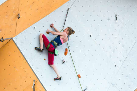Cute female Athlete hanging on climbing Wallのeditorial素材