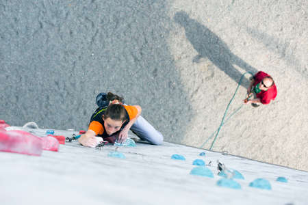 Junior female Athlete on climbing Wall and belaying refereeのeditorial素材