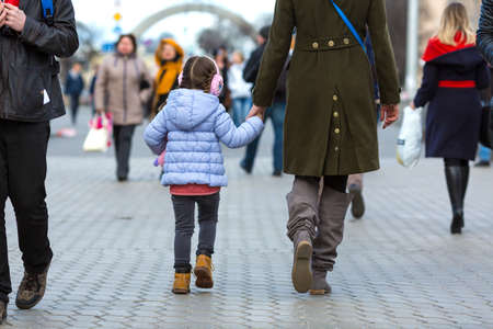 Mother and Daughter walking on City Street among Crowdの写真素材