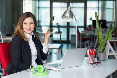 Smiling Business Lady in official clothing holding Coffee Mugの写真素材