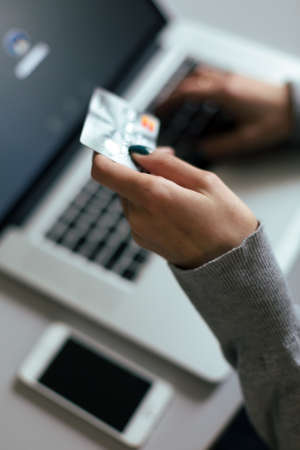 Person shopping making Payment at Computer using Credit Cardの写真素材