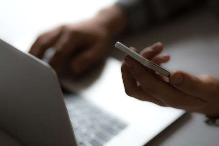 Man holding Telephone in front of Laptopの写真素材