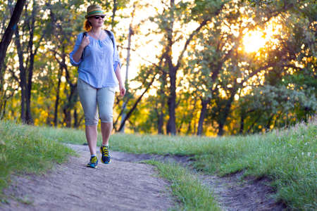 Female Hiker walking on Trail at Sunsetの写真素材