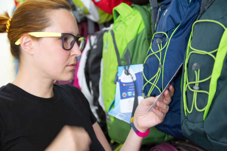 Female Customer choosing backpack at Retail Shopの写真素材