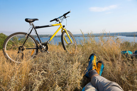Biker in bright sporty Shoes resting on Grassの写真素材