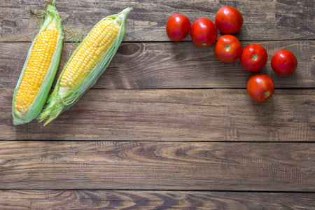 Summer Harvest Composition on Wooden Background Corn and Tomatoの写真素材