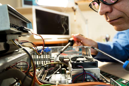 Computer Technician repairing Hardware with toolsの写真素材