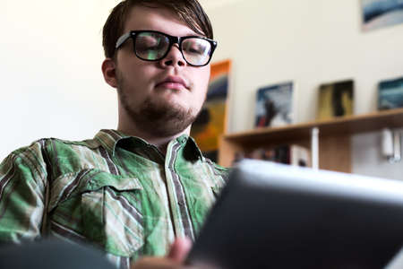 Portrait of Young Man using Tablet Computer in Home Interiorの写真素材