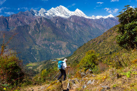 Mature Male hiker in white shirt walking on Mountain Trailの写真素材