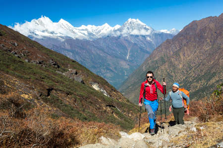 Young Hiker walking on Mountain Trail along with local Guideの写真素材