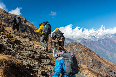 Group of People walking up on steep Mountain Trailの写真素材