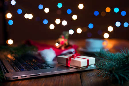 Greetings throw Internet Concept on wood Table with Christmas Lightsの写真素材