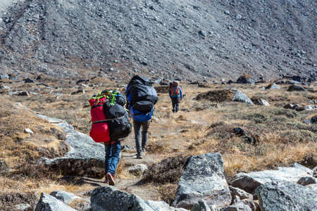 Sherpa Porters carrying lots of heavy luggageの写真素材