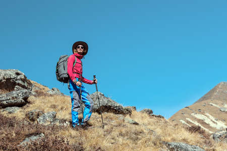 Young Hiker staying on grassy Mountain Slopeの写真素材