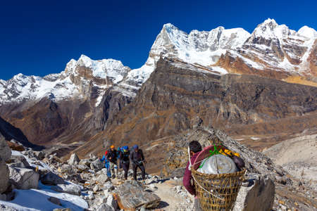 Group of Hikers and Nepalese Porter carrying many camping luggageの写真素材