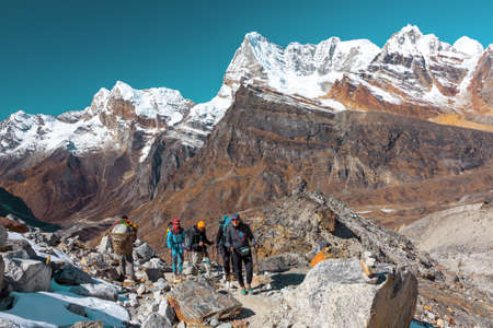 Group of Hikers and Nepalese Porter carrying many camping luggageの写真素材