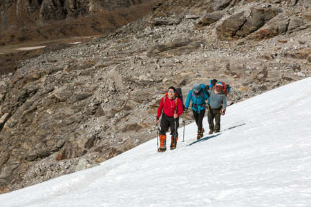 Alpine Climbers heavily stepping up on Snow Slopeの写真素材