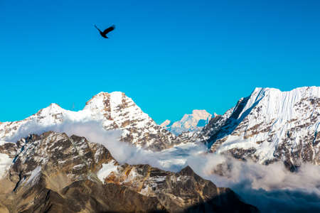 Mountain view at high altitude clouds sky and bird flyingの写真素材
