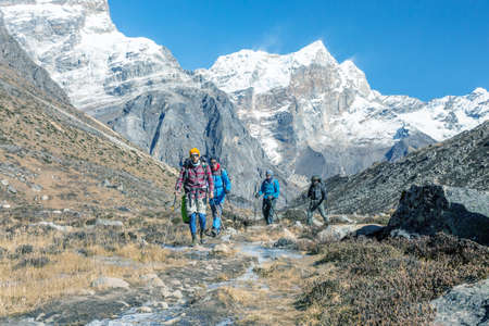 Group of Hikers walking along Creek in high Mountains tonedの写真素材