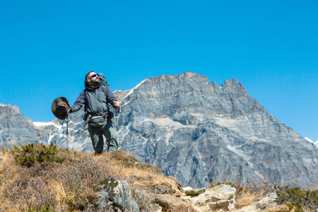 Hiker in dark grey Jacket and Pants in the Mountainsの写真素材