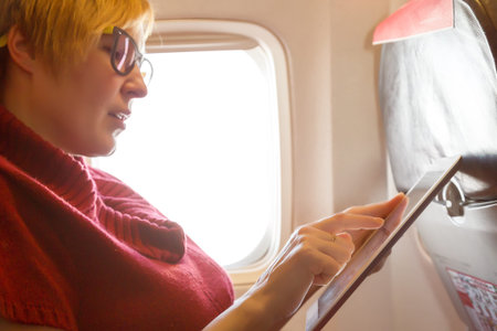 Female Passenger using Tablet PC during Flight