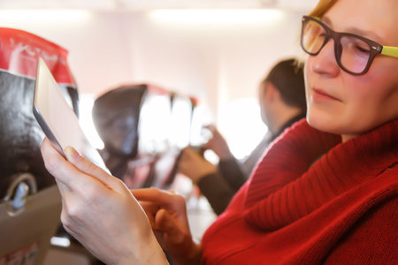 Female Passenger using Tablet PC during Flightの写真素材