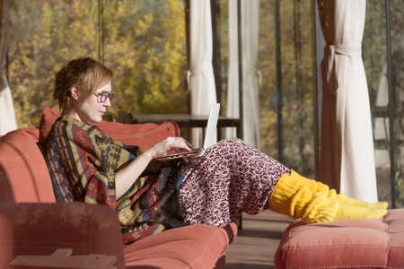 Lady in traditional Clothing working on Computer in Home Interiorの写真素材
