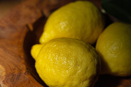 three amalfi lemons in an olive wood bowl