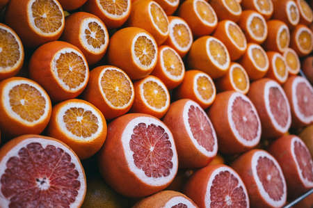 Rows of ripe juicy cut oranges and grapefruits on the marketの写真素材