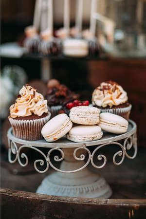 Metal stand under the capcake with cream, macaroons. Candy barの写真素材