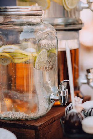 Fresh citrus lemonade with lemons in beverage dispenser, glass jarの写真素材
