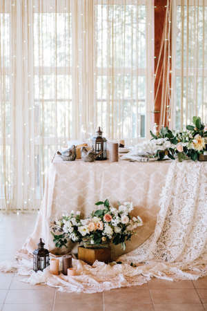 Elegant wedding table in the style of vintage and rustic decorated with flowers, white lace, tablecloth and candles. Verticalの写真素材