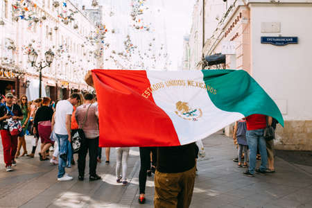 MOSCOW, RUSSIA - JUNE 2018 A fan with the flag of Mexico is walking along Nikolskaya Street in the center of Moscow during the World Cupのeditorial素材
