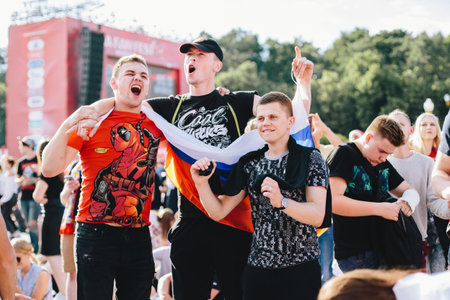 MOSCOW, RUSSIA - JUNE 2018 Three Russian fans are happy and jumping with the national flag in the...