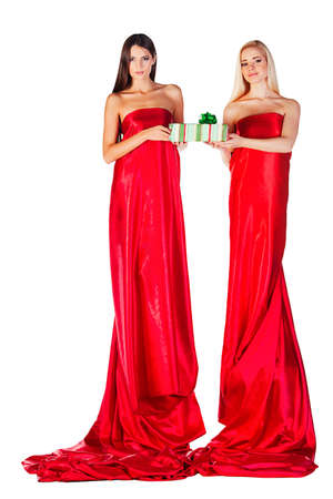 two women in red dress with present in hands on white backgroundの写真素材