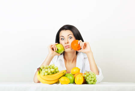 funny woman with apple and orangeの写真素材
