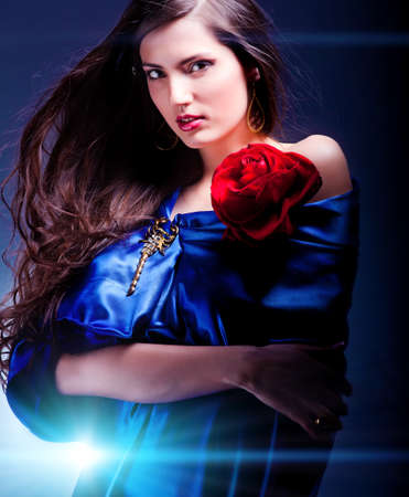 portrait of a beautiful woman in blue dress whith roseの写真素材