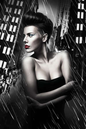 beautiful woman with red lips in rainy cityの写真素材