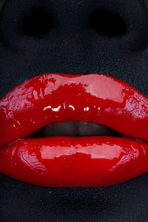 Glossy red lips and black skinの写真素材