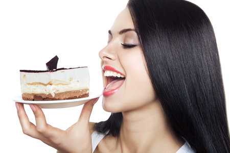 girl biting cake on white background