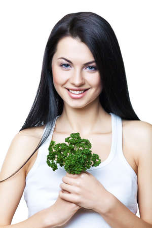 smiling girl with parsley in hands on white backgroundの写真素材