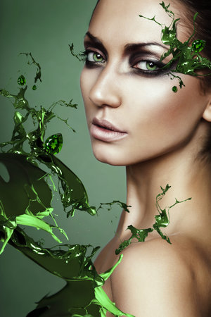 close up portrait of woman in green plant splashの写真素材