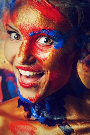 portrait of cheerful girl in paints