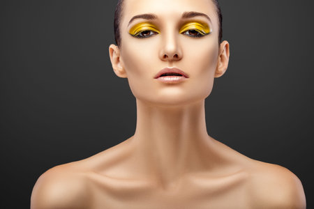beautiful woman with yellow eye shadow on Grey backgroundの写真素材