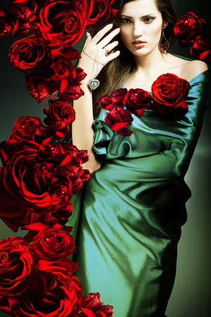 beautiful woman in green fabric with red rosesの写真素材