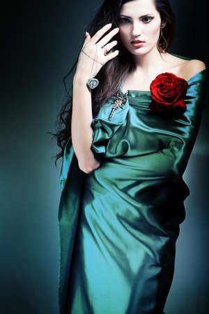 beautiful woman in green fabric with red roseの写真素材