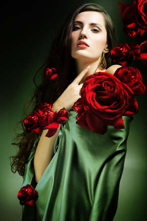 woman in green fabric with red rosesの写真素材